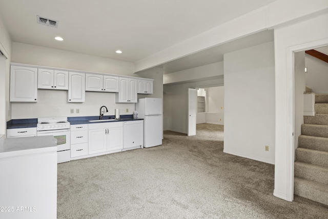 kitchen with light carpet, white appliances, a sink, visible vents, and white cabinetry