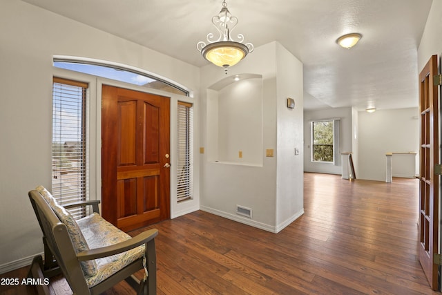 foyer featuring dark wood finished floors, visible vents, and baseboards