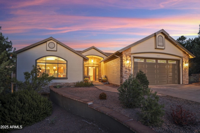 view of front of property with driveway, stone siding, and an attached garage