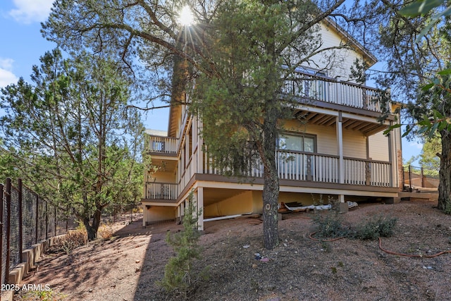 rear view of property featuring fence and a deck