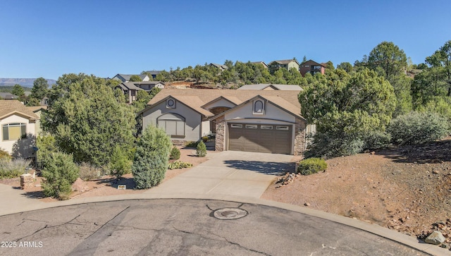 view of front facade with a garage, stone siding, and concrete driveway