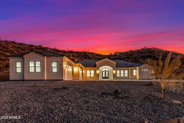 view of front of property featuring a garage, french doors, a mountain view, and stucco siding