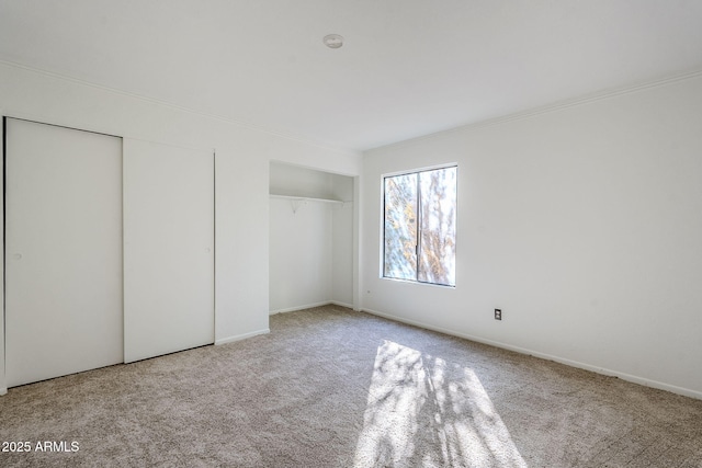 unfurnished bedroom featuring multiple closets and light carpet