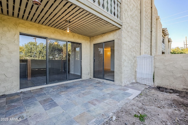 view of exterior entry with a patio area