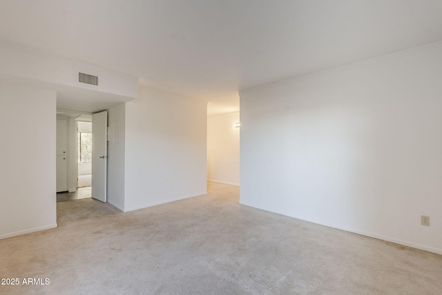 spare room with ornamental molding and light colored carpet