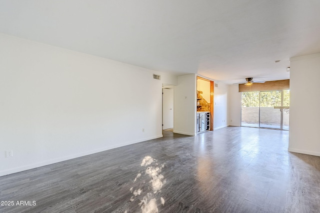 unfurnished living room with dark wood-type flooring, ornamental molding, and ceiling fan