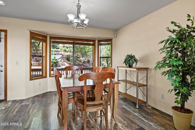 dining space with a wealth of natural light, a notable chandelier, and dark wood-type flooring