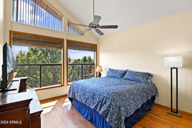 bedroom featuring ceiling fan, hardwood / wood-style floors, and multiple windows