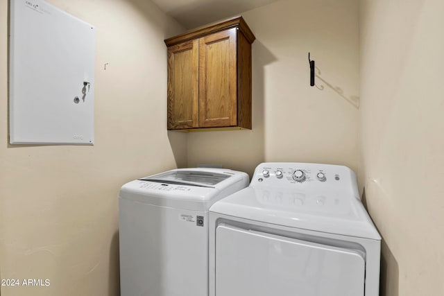 washroom featuring cabinets and washer and clothes dryer