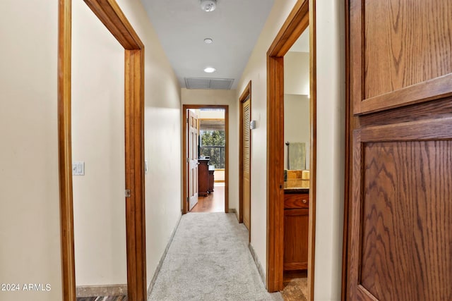 hall featuring light colored carpet