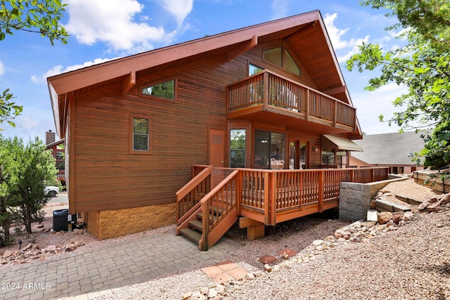 back of property featuring a balcony, a deck, and central AC