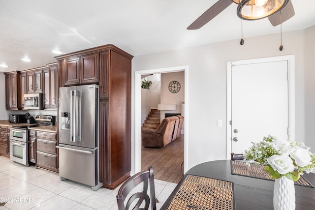 kitchen featuring ceiling fan, light hardwood / wood-style floors, dark brown cabinetry, and stainless steel appliances