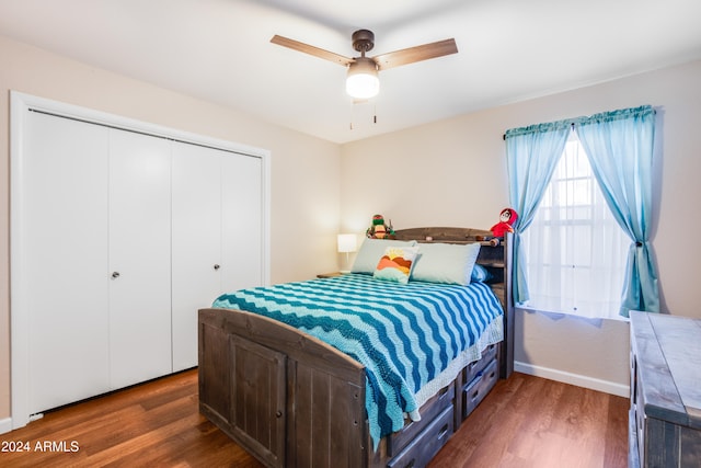 bedroom with a closet, dark wood-type flooring, and ceiling fan