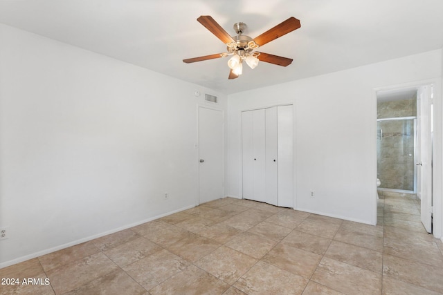 unfurnished bedroom with a closet, ensuite bath, and ceiling fan