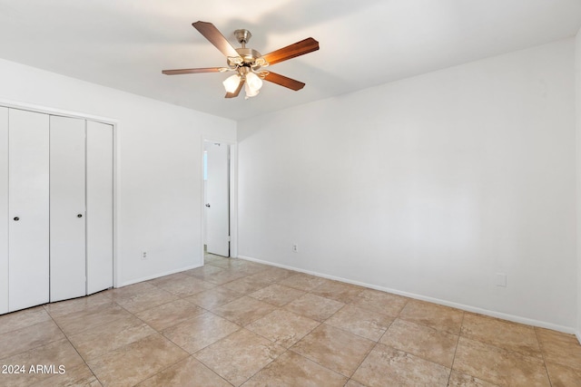 unfurnished bedroom featuring ceiling fan and a closet