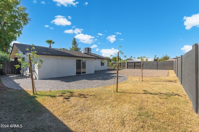 view of yard with cooling unit and a patio