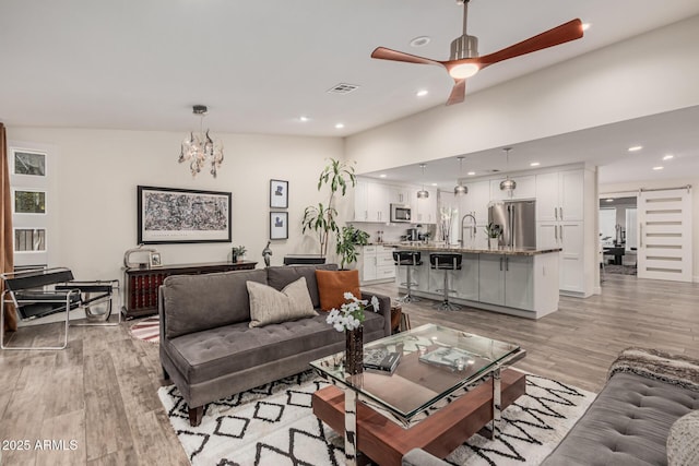 11822 S Coconino St, Phoenix, AZ 85044 - living room featuring light wood finished floors, a ceiling fan, recessed lighting, and a chandelier