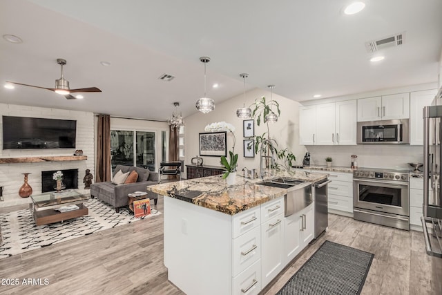 11822 S Coconino St, Phoenix, AZ 85044 - kitchen with stainless steel appliances, open floor plan, light stone counters, white cabinets, and recessed lighting