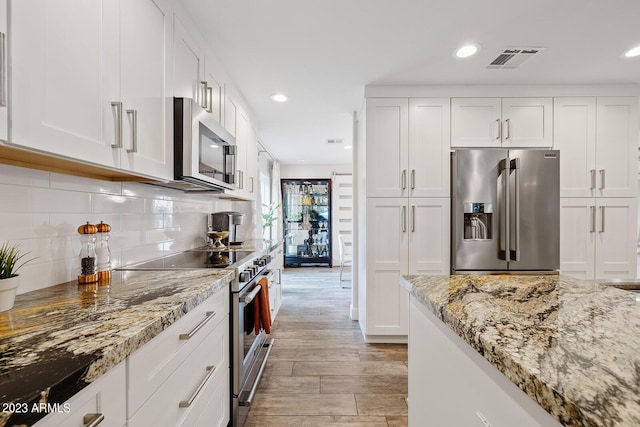11822 S Coconino St, Phoenix, AZ 85044 - kitchen with stainless steel appliances, white cabinetry, light stone countertops, recessed lighting, and decorative backsplash