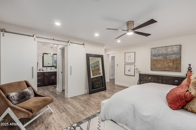11822 S Coconino St, Phoenix, AZ 85044 - bedroom featuring a barn door, light wood-style flooring, baseboards, ensuite bath, and recessed lighting