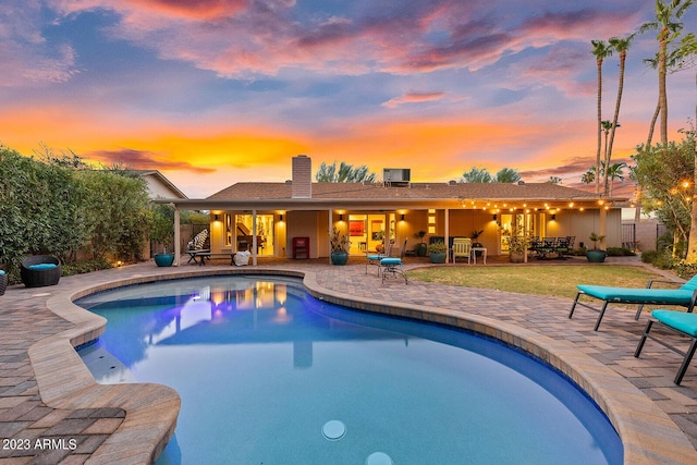 11822 S Coconino St, Phoenix, AZ 85044 - pool at dusk featuring a patio area and a lawn