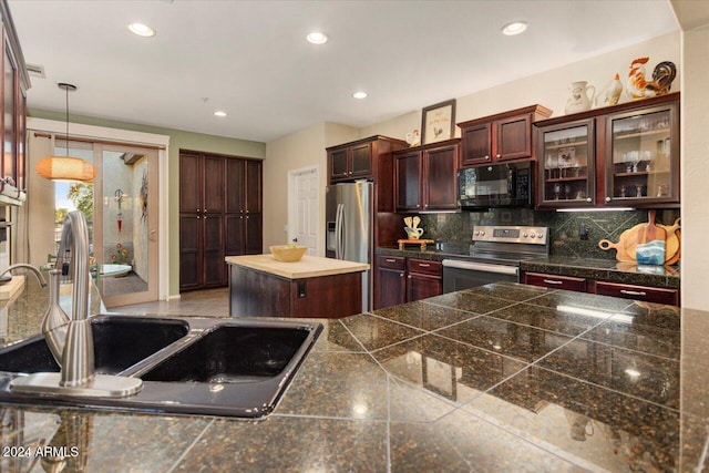 kitchen with pendant lighting, a center island, backsplash, sink, and appliances with stainless steel finishes