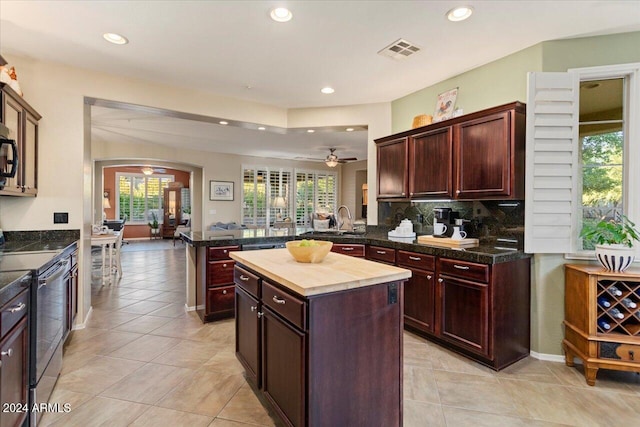 kitchen with kitchen peninsula, appliances with stainless steel finishes, backsplash, ceiling fan, and a center island