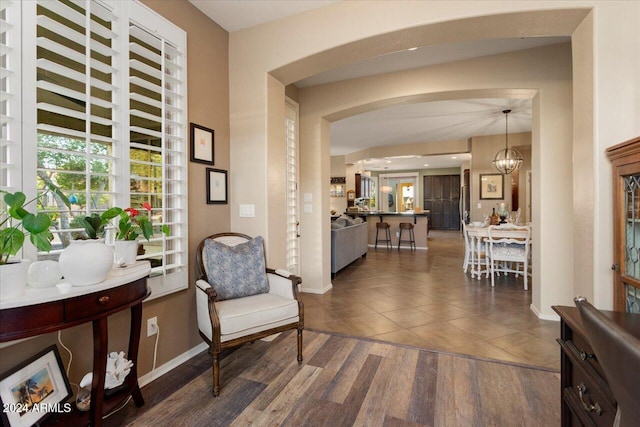 sitting room with dark wood-type flooring and a chandelier