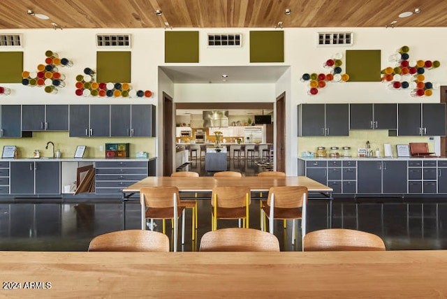 kitchen with sink, a breakfast bar area, and wood ceiling