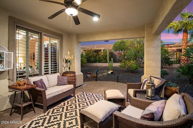 patio terrace at dusk featuring outdoor lounge area and ceiling fan