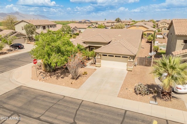 44574 W High Desert Trl, Maricopa, AZ 85139 - view of front facade featuring fence, a tiled roof, an attached garage, driveway, and a residential view
