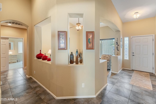 44574 W High Desert Trl, Maricopa, AZ 85139 - entryway featuring a ceiling fan, arched walkways, tile patterned floors, baseboards, and a high ceiling