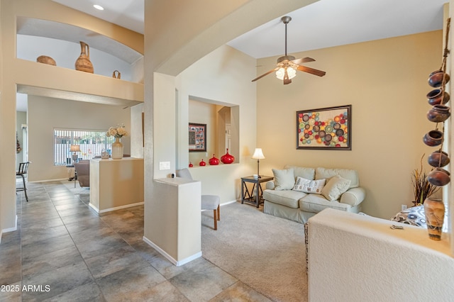 44574 W High Desert Trl, Maricopa, AZ 85139 - living area with baseboards, carpet flooring, a towering ceiling, and ceiling fan