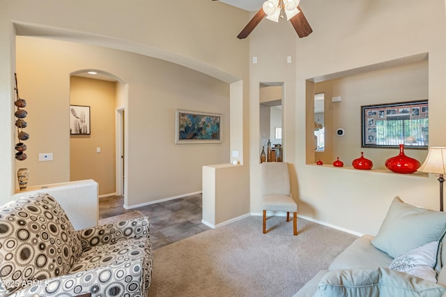 44574 W High Desert Trl, Maricopa, AZ 85139 - living room featuring carpet floors, baseboards, ceiling fan, a high ceiling, and arched walkways