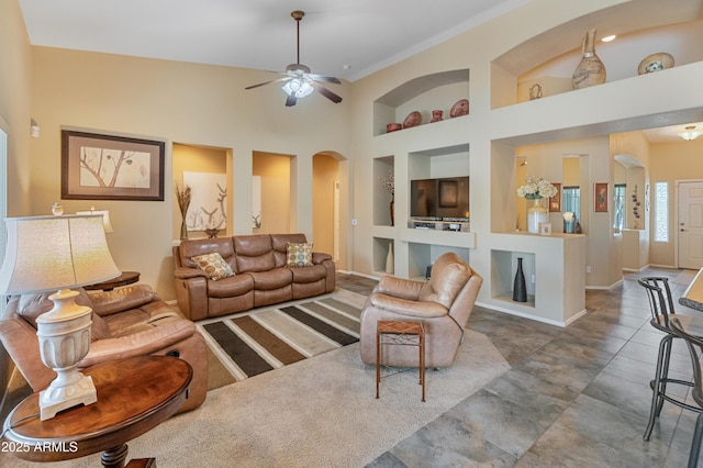 44574 W High Desert Trl, Maricopa, AZ 85139 - living room with arched walkways, a ceiling fan, built in features, and baseboards