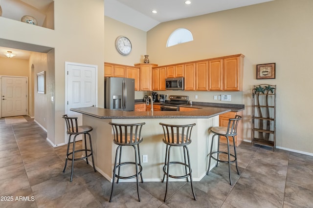 44574 W High Desert Trl, Maricopa, AZ 85139 - kitchen featuring dark countertops, high vaulted ceiling, baseboards, stainless steel appliances, and an island with sink