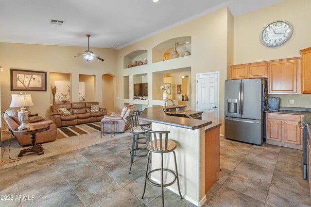 44574 W High Desert Trl, Maricopa, AZ 85139 - kitchen with stainless steel fridge, dark countertops, high vaulted ceiling, and a sink