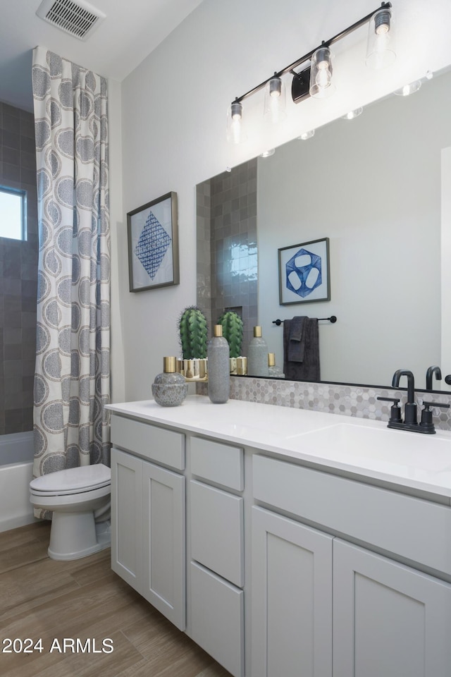 full bath with vanity, wood finished floors, visible vents, shower / bath combination with curtain, and toilet