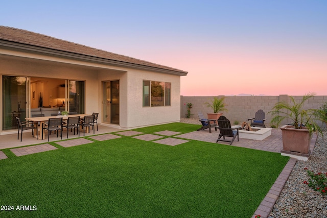 yard at dusk featuring a patio area, a fenced backyard, and an outdoor fire pit