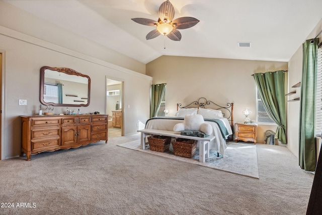 carpeted bedroom with ensuite bath, lofted ceiling, and ceiling fan