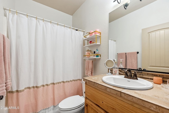 bathroom featuring toilet, curtained shower, and vanity