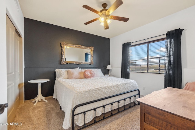 bedroom with a closet, light colored carpet, and ceiling fan