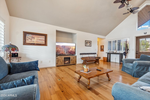 living room with light hardwood / wood-style flooring, high vaulted ceiling, and ceiling fan