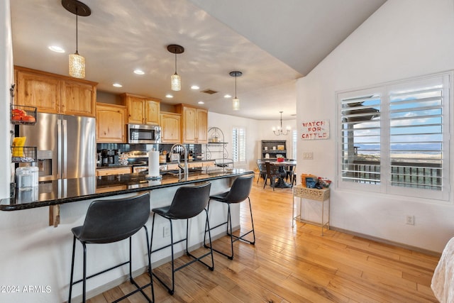 kitchen with a wealth of natural light, pendant lighting, and stainless steel appliances