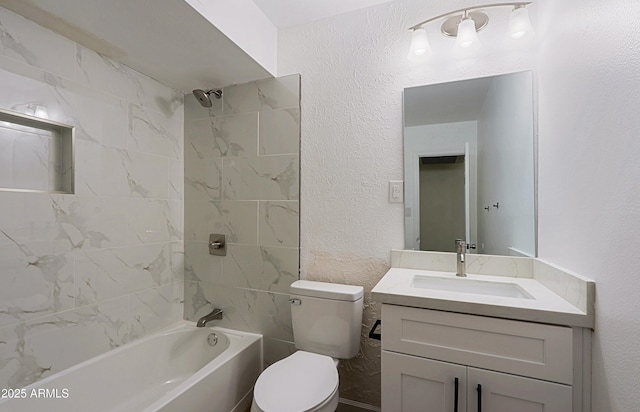 full bathroom featuring tiled shower / bath combo, vanity, and toilet