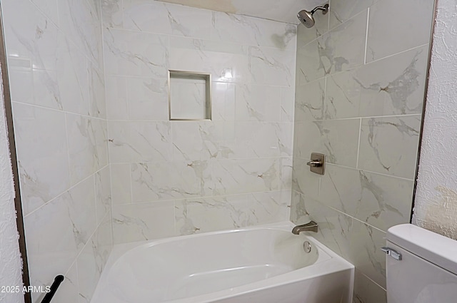 bathroom featuring toilet and tiled shower / bath