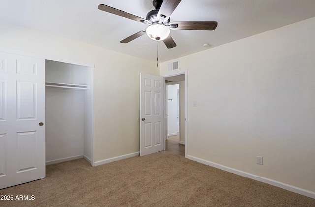 unfurnished bedroom with ceiling fan, carpet, and a closet