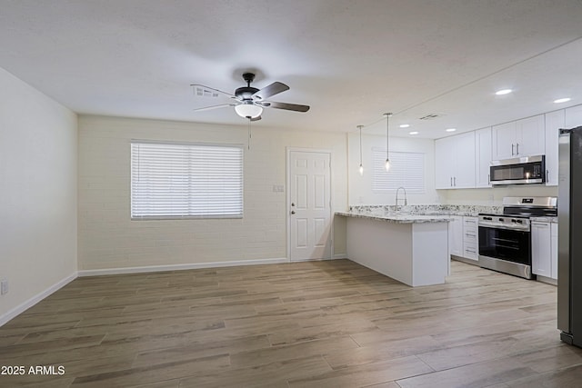 kitchen featuring ceiling fan, kitchen peninsula, white cabinetry, light hardwood / wood-style flooring, and stainless steel appliances