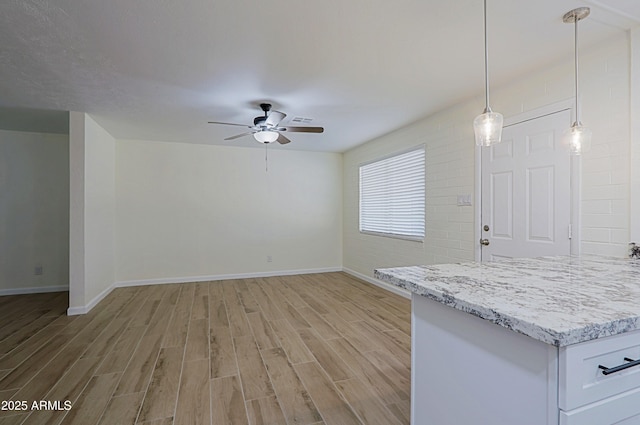 unfurnished living room with ceiling fan and light hardwood / wood-style flooring