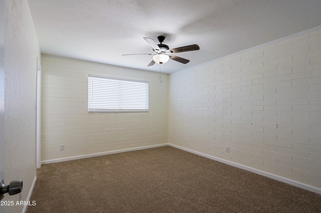 unfurnished room with carpet, ceiling fan, and brick wall